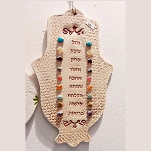 A small hamsa with blessings and stones